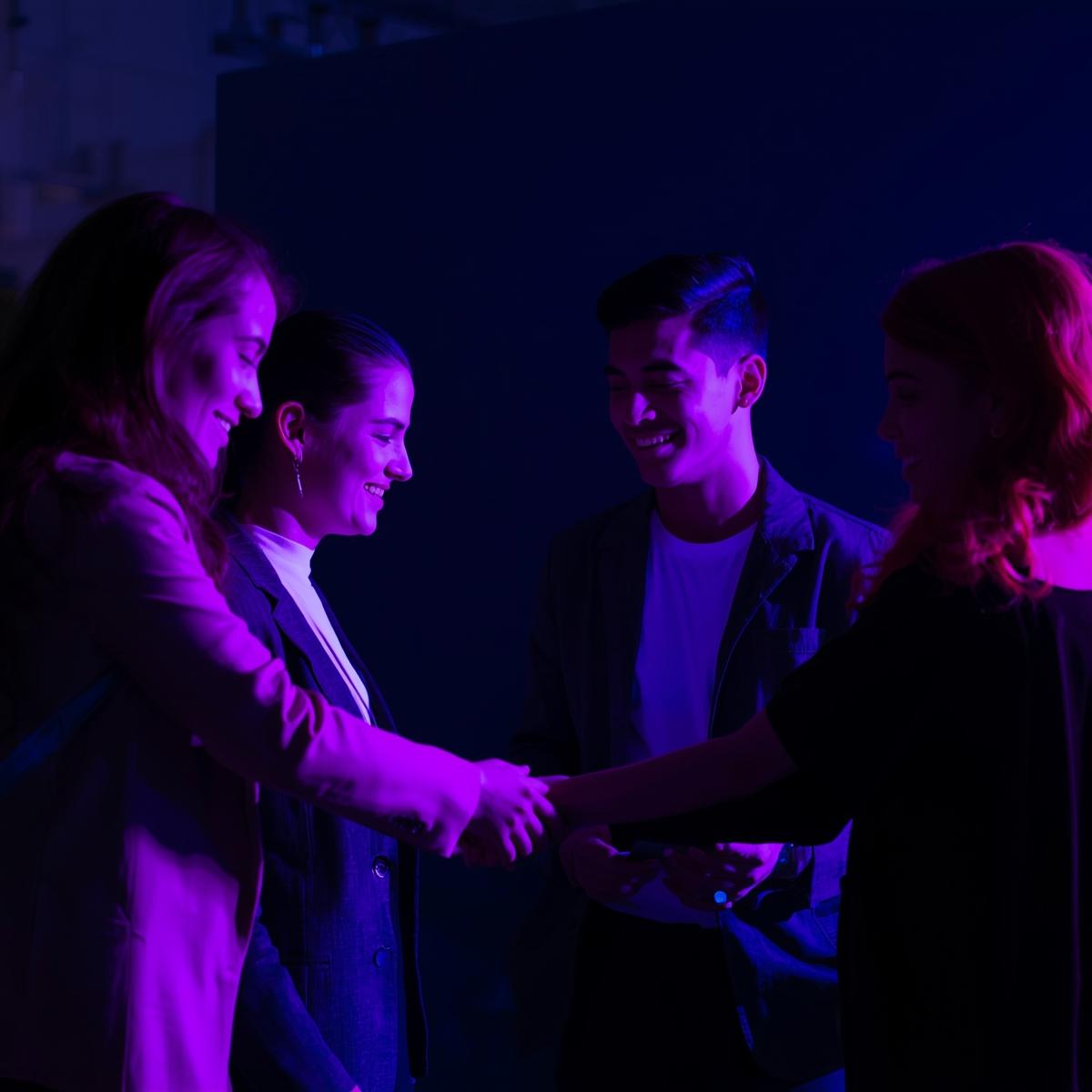 Young professionals connecting in person, lit in neon tones